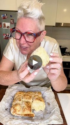 an older woman holding a piece of bread in front of her face