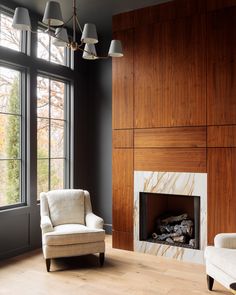 a living room filled with furniture and a fire place in front of a large window