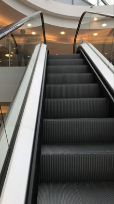 an escalator in a building with people walking up and down it's sides