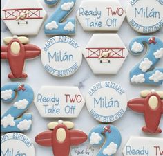 decorated cookies are arranged in the shape of airplanes and numbers for two birthdays, ready to take off