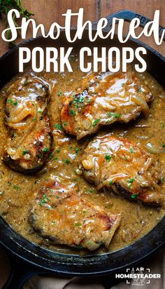 pork chops with gravy in a skillet on top of a wooden table