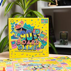 a yellow board game sitting on top of a table next to a potted plant