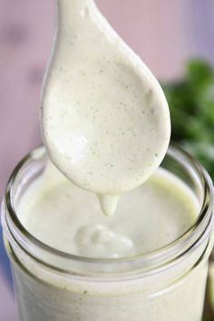 a spoon full of cream sitting on top of a jar