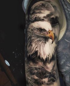 an eagle tattoo on the arm and shoulder is shown in black and grey colors,