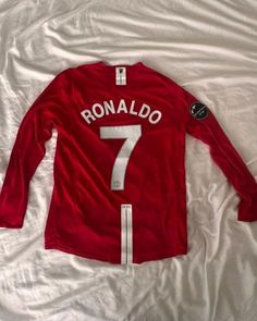 a red shirt with the number seven on it is laying on a white bed sheet