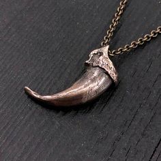 Discover the wild elegance of this unique wolf claw necklace, meticulously cast in solid jeweler's grade bronze from a real North American Gray Wolf claw. Measuring 1-1/4", this piece came from an exceptionally large specimen, making it a rare find. Every intricate detail of the original claw has been captured in this bronze recreation, slightly oxidized to enhance its deep, rich hue. Unlike typical designs, this necklace features a carefully bored hole through the knuckle, allowing the chain to Animal Accessories Jewelry, Viking Style Bronze Jewelry Gift, Brass Claw Jewelry As Gift, Medieval Bronze Jewelry With Antique Finish, Medieval Style Bronze Jewelry With Antique Finish, Medieval Style Hand Cast Bronze Jewelry, Bronze Engraved Medieval Jewelry, Medieval Engraved Bronze Jewelry, Hand Cast Claw Necklace As Gift