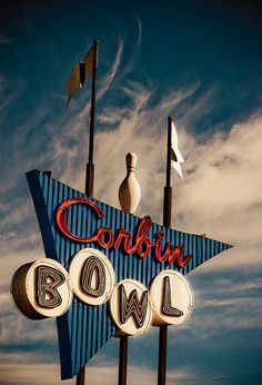 an old neon sign with bowling pins and balls on it's roof that says coburn bowl