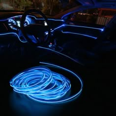 the interior of a car is lit up with blue neon lights and steering wheel rings