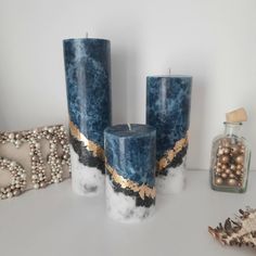 three blue candles sitting on top of a table next to some shells and other decorations