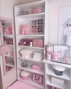 a room filled with lots of white shelves and pink accessories on top of it's shelves