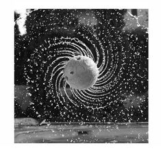 a black and white photo of water bubbles in the air, with an image of a fish coming out of it's mouth