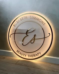 the logo for elizabeth simmons's beauty therapy is lit up in front of a wall