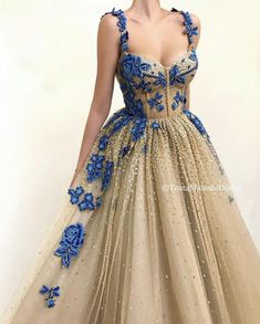 Details - Gold color - Sparkling tulle fabric  - Handmade embroidered unique blue flowers - A-line shape with waist definition  - For special occasions Blue And Gold Dress, Teuta Matoshi, Flowers Unique, Fantasy Gowns, Dress Shapes, Fancy Outfits, Beautiful Gowns, Formal Gowns, Fancy Dresses