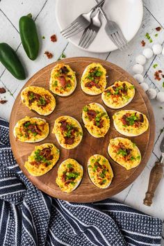 an overhead view of deviled eggs on a wooden platter with knife and fork