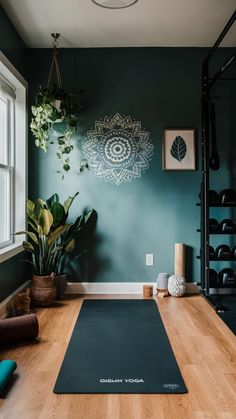 a yoga mat is on the floor in front of a green wall and some plants