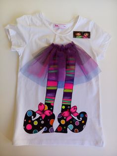 a white t - shirt with colorful polka dot shoes on the front and purple tulle skirt