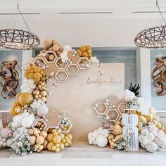 balloons and flowers are arranged on the wall in front of a backdrop with honeycombs