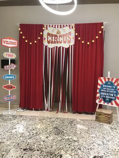 a circus themed party with red drapes and signs on the front door, hanging from ceiling