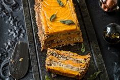 slices of cake sitting on top of a metal tray next to a knife and fork