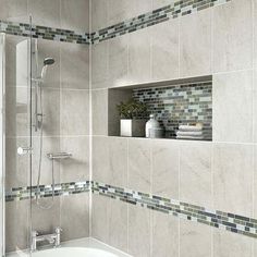 a bathroom with tiled walls and white bathtub