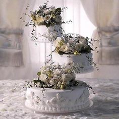 a three tiered cake with white flowers on top