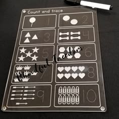 a sheet of stickers with numbers and symbols on it, next to a marker