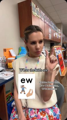 a woman is sitting in a chair and pointing at the camera with an ew logo on it