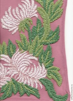 a pink pillow with white and green flowers on it