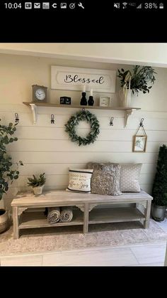 a white bench with pillows and wreaths on the wall above it, along with other decorations