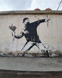 a painting on the side of a building with a man holding flowers