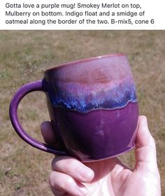 someone holding up a purple coffee cup with blue and pink glazes on it