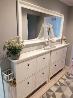 a large white dresser sitting next to a mirror