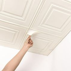 someone is painting the ceiling with white paint