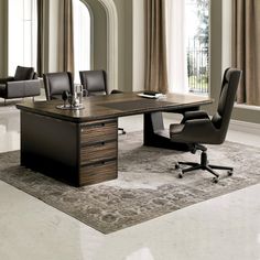 an office desk with chairs and a rug in front of the table, along with two windows