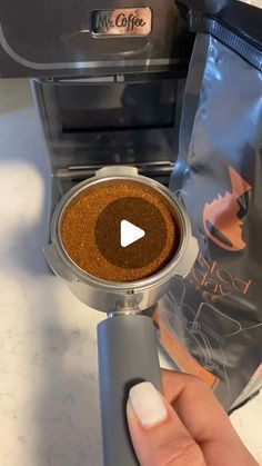 a person is pressing the button on a coffee grinder to make their own espresso