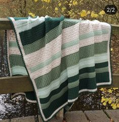 a green and white blanket sitting on top of a wooden bench