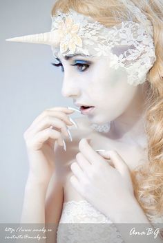 a woman with white makeup and horns on her head