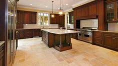 a large kitchen with wooden cabinets and an island in front of the stove top oven