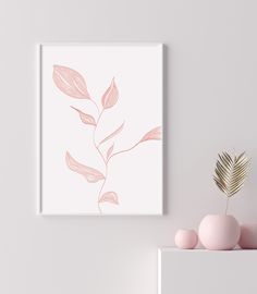 a pink plant sits on a shelf next to a white wall with a framed print