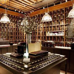 a room filled with lots of wooden shelves covered in boxes and lights hanging from the ceiling