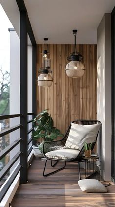 a balcony with two hanging lights and a chair on the floor next to a potted plant