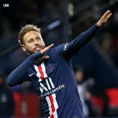 a soccer player throwing a ball in the air with his hand out to catch it