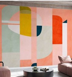 a living room filled with furniture next to a wall painted in pink and orange colors