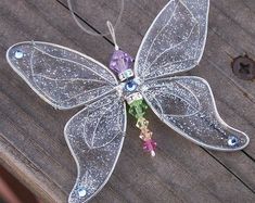 a glass ornament that is sitting on a wooden table with beads and crystals