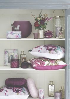 the shelves are filled with decorative items such as pillows, candles and vases on them