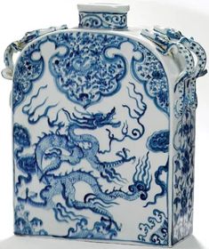 a blue and white vase with dragon designs on it