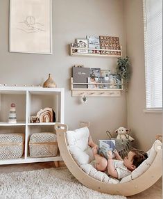 a young child laying in a hammock reading a book while sitting on the floor