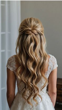 the back of a woman's head with long, wavy hair in her wedding dress