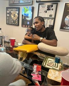 two men sitting at a table with doughnuts and drinks