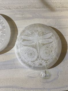 two white plates sitting next to each other on a wooden table with lace doily